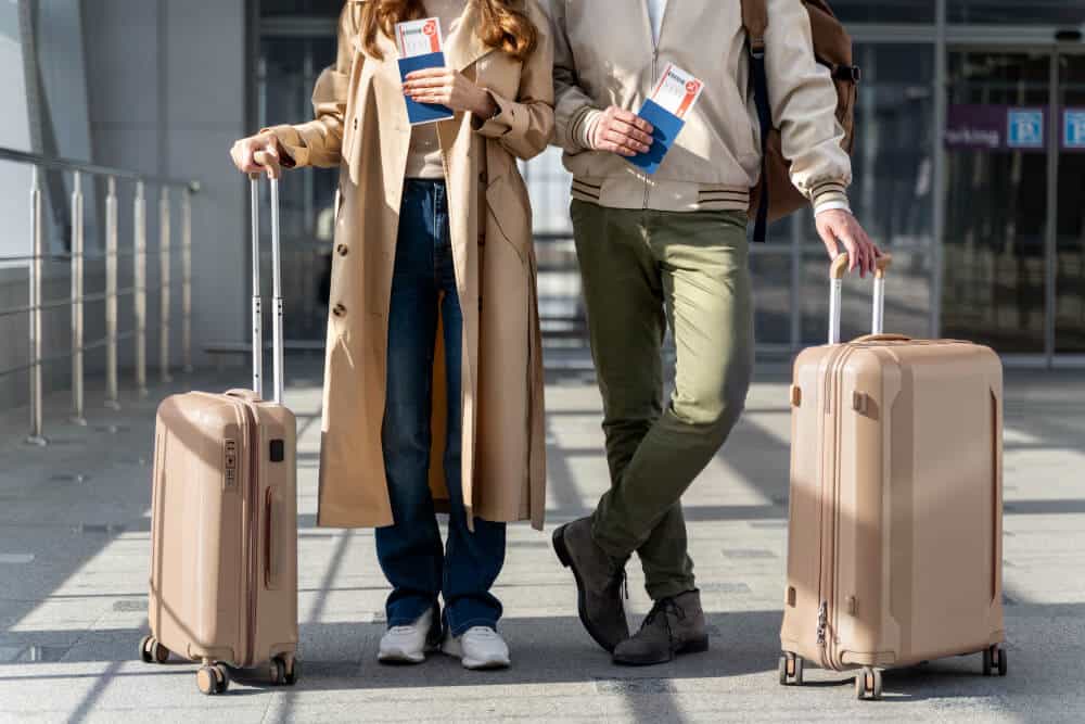 Travelers with luggage holding passports and travel documents
